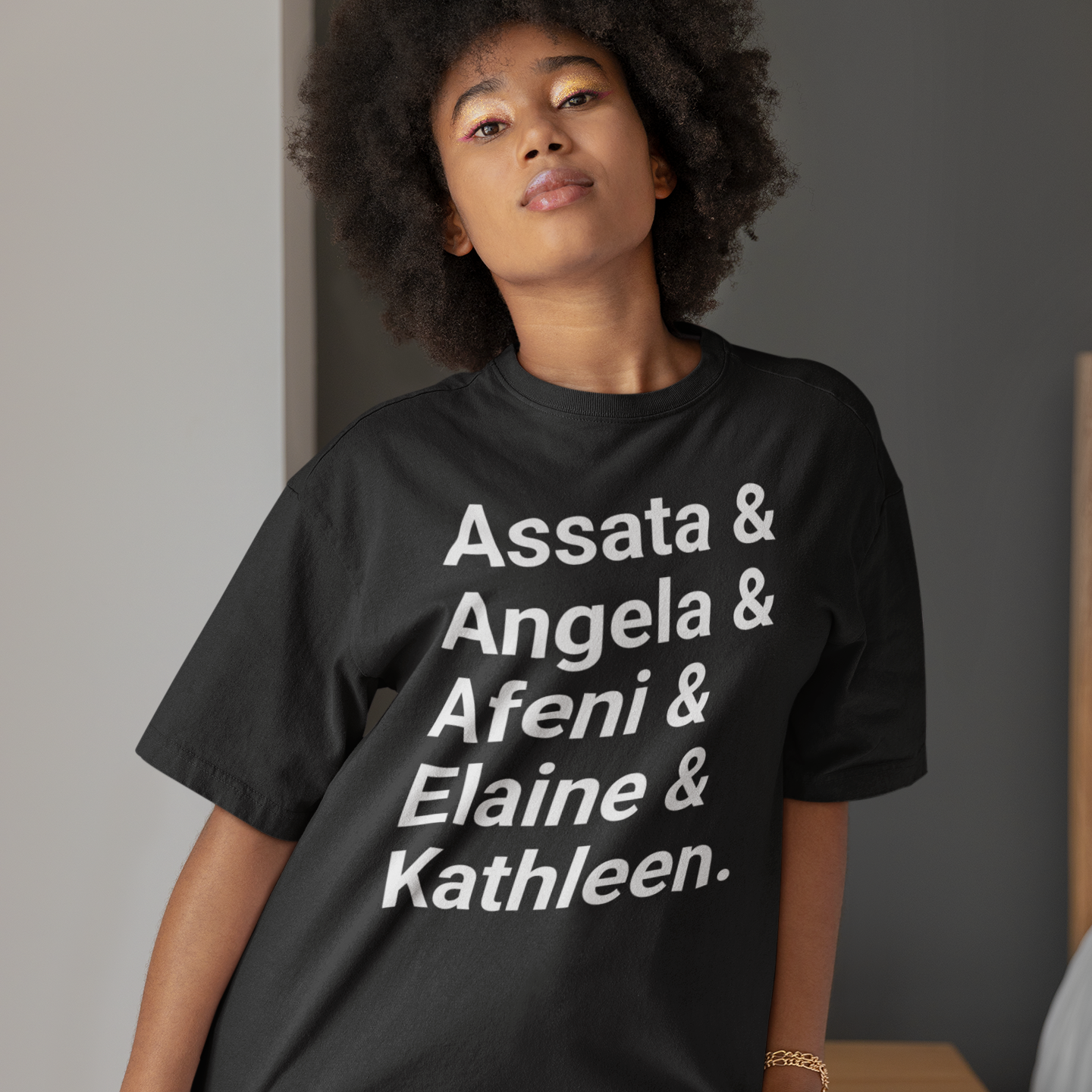 Black woman standing indoors wearing revolutionary women t shirt from tru nobility