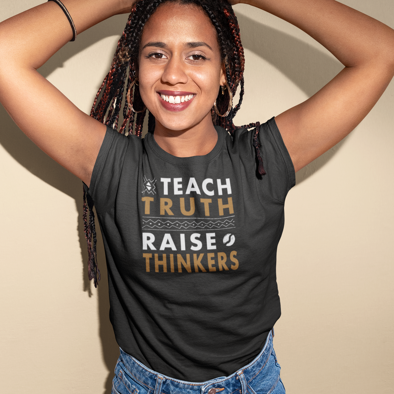 Person wearing a black tank top with text, standing against a beige background
