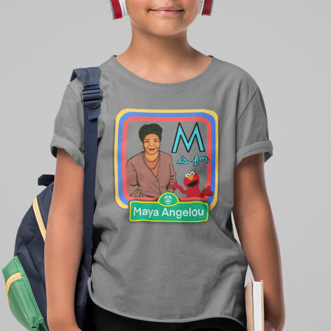 Child wearing a t-shirt with a graphic of Maya Angelou and Elmo, with 'M is for Maya Angelou' text.